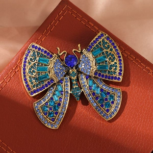 Vintage gold butterfly brooch with blue and turquoise crystals on brown leather base