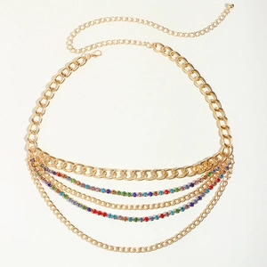 Détail d'une chaîne de taille dorée multicouche avec strass colorés et fermoir mousqueton