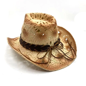 Detail of western straw cowboy hat with brown leather band and weathered vintage finish