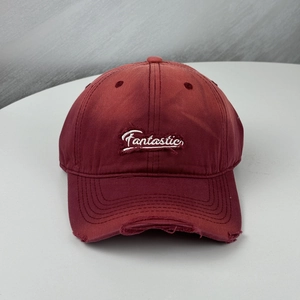 Détail d'une casquette de baseball bordeaux avec broderie Fantastic et finitions usées