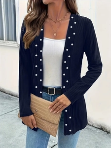 Close-up of ribbed black cardigan featuring intricate white pearl beading on the placket