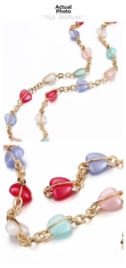 Macro view of colorful heart-shaped beads on a gold-plated copper chain necklace