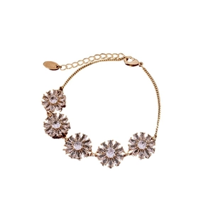 Bracelet floral plaqué or 18 carats avec zircons et chaîne réglable sur fond blanc