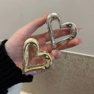 Detail of heart-shaped metal hair claws in gold and silver finish for women's hair styling