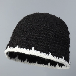 Detailed close-up of thick knit bucket hat with black and white wavy contrast edges