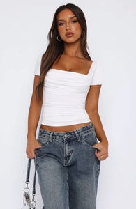 White short sleeve slim fit top with elegant ruching detail paired with dark denim jeans