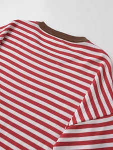 Detail of red and white striped knit sweater featuring a brown ribbed crew neck collar