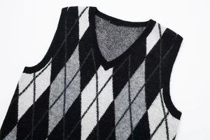 Close-up detail of the V-neck and diamond pattern knit texture on the sweater vest