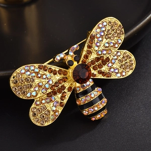 Detailed macro shot of a golden bee brooch with sparkling brown and rainbow rhinestones