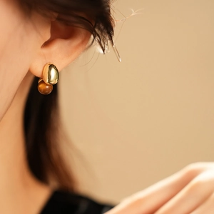Close-up of elegant French vintage earrings with faux tiger eye stones and golden finish