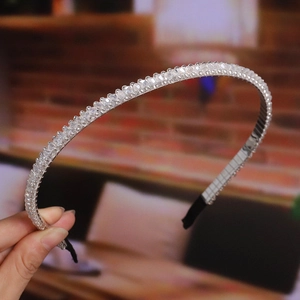 Close-up of handmade beaded headband with clear crystal beads and silver wire finish