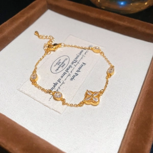 Macro shot of gold floral bracelet with white zircons and pearls in a wooden gift box