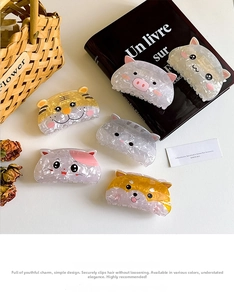 Flat lay of cute animal acetate hair claws featuring cat, tiger and shiba inu designs