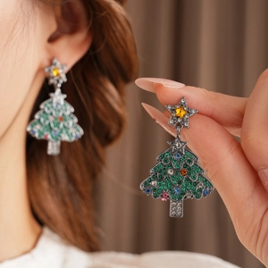 Detailed view of vintage green Christmas tree earrings with colorful crystal rhinestones