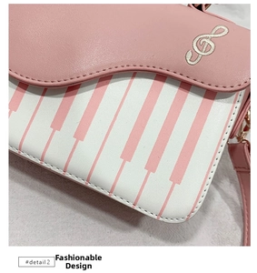 Detail of pink piano key print and treble clef embroidery on a stylish crossbody bag