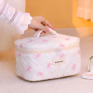 Beauty case trapuntato in cotone bianco con fiocchi rosa e manico per i tuoi viaggi