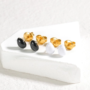 Boucles d'oreilles ovales en émail noir et blanc sur un socle en pierre blanche