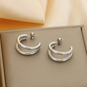 Close-up of silver double hoop earrings displayed on champagne satin and jewelry box