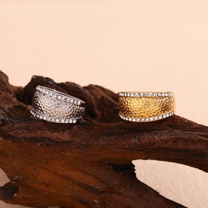 Detailed view of gold and silver hammered band rings with tiny rhinestones on wood