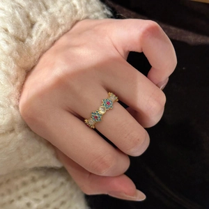 Detail of 18k gold plated flower ring with blue enamel and pearl on model hand