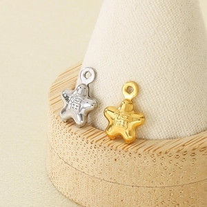 Gold and silver star pendants with 'Fu' relief on wood and beige display stand