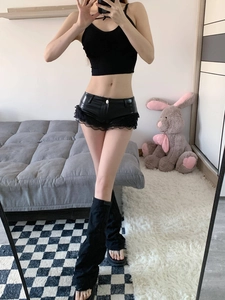 Dettaglio di pantaloncini in pelle PU nera con pizzo e top corto abbinato in un selfie allo specchio