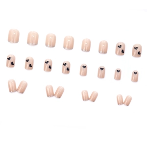 Nude pink short round press-on nails with black heart patterns and silver glitter tips