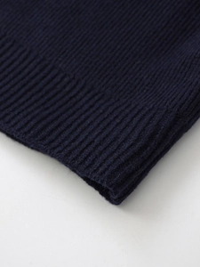 Macro shot of navy blue knitwear featuring detailed ribbed texture and soft wool blend fiber