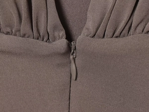 Detail of V-neck collar showing invisible zipper and textured brown knit fabric