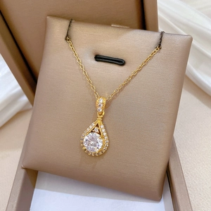 Macro detail of teardrop gold necklace with shimmering cubic zirconia in a jewelry box