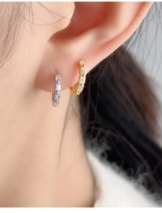 Close-up of S925 silver hoop earrings with rectangular white zircons in gold and silver