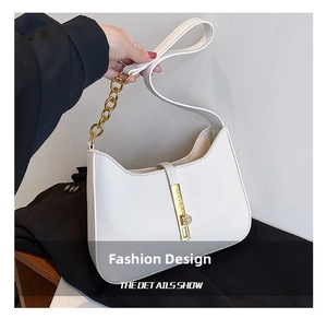 Detailed close-up of white minimalist shoulder bag featuring gold chain strap and metal lock