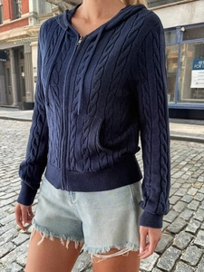 Detail of navy blue knit hoodie with zipper, drawstring and texture on model