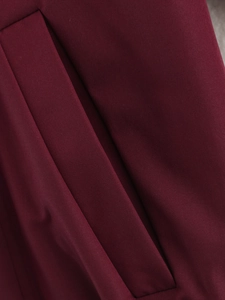Vue macro des coutures de poche et du tissu uni de la veste rouge vin