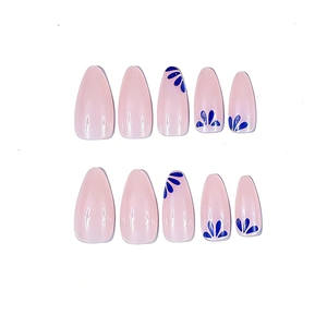 Detail of long almond press-on nails with minimalist blue flower designs and glossy finish