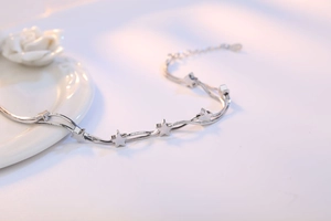 Detailed view of silver double-layered snake chain bracelet with polished star charms