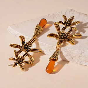 Detail of vintage gold flower earrings with amber water drop pendants on stone