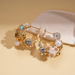 Luxurious gold flower earrings featuring faux pearls and crystals on beige background