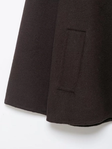 Macro shot of dark brown wool blend coat featuring pocket flap and precise stitching details