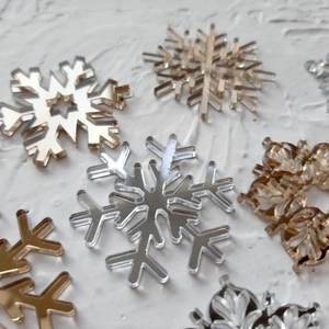 Detailed view of assorted gold and silver acrylic mirror snowflake cake toppers