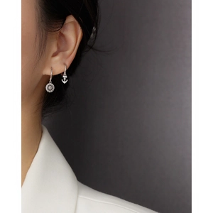 Detail view of S925 silver hoop earrings with rudder and anchor charms on model