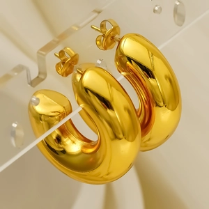 Minimalist golden chunky C-shaped hoop earrings with a high-polished metallic finish