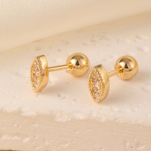 Detail of eye-shaped gold stud earrings with white zircon stones and ball backings