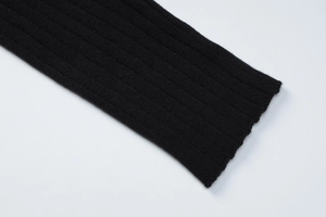 Gros plan détaillé sur la texture en maille côtelée noire de la manche du cardigan