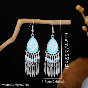 Macro detail of bohemian waterdrop earrings with colorful enamel and silver tassels