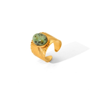 Vintage gold open ring with oval green stone and radiating fan texture on steel band