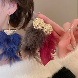 Elegant gold textured round studs with vibrant feather fringe tassels in blue, brown and red
