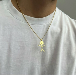 Close-up of a gold funny doodle necklace featuring a middle finger stickman pendant
