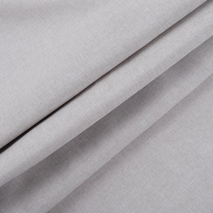 Dettaglio ravvicinato della trama e del drappeggio dei pantaloni larghi in lino grigio chiaro