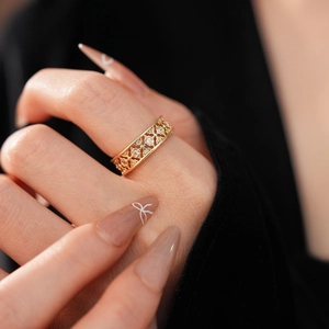 Close-up of gold-plated hollow flower ring with white zircon stones on a model